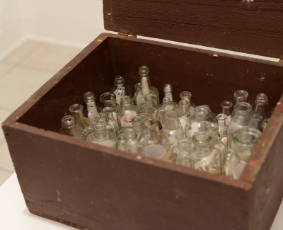 Wooden box full of glass bottles